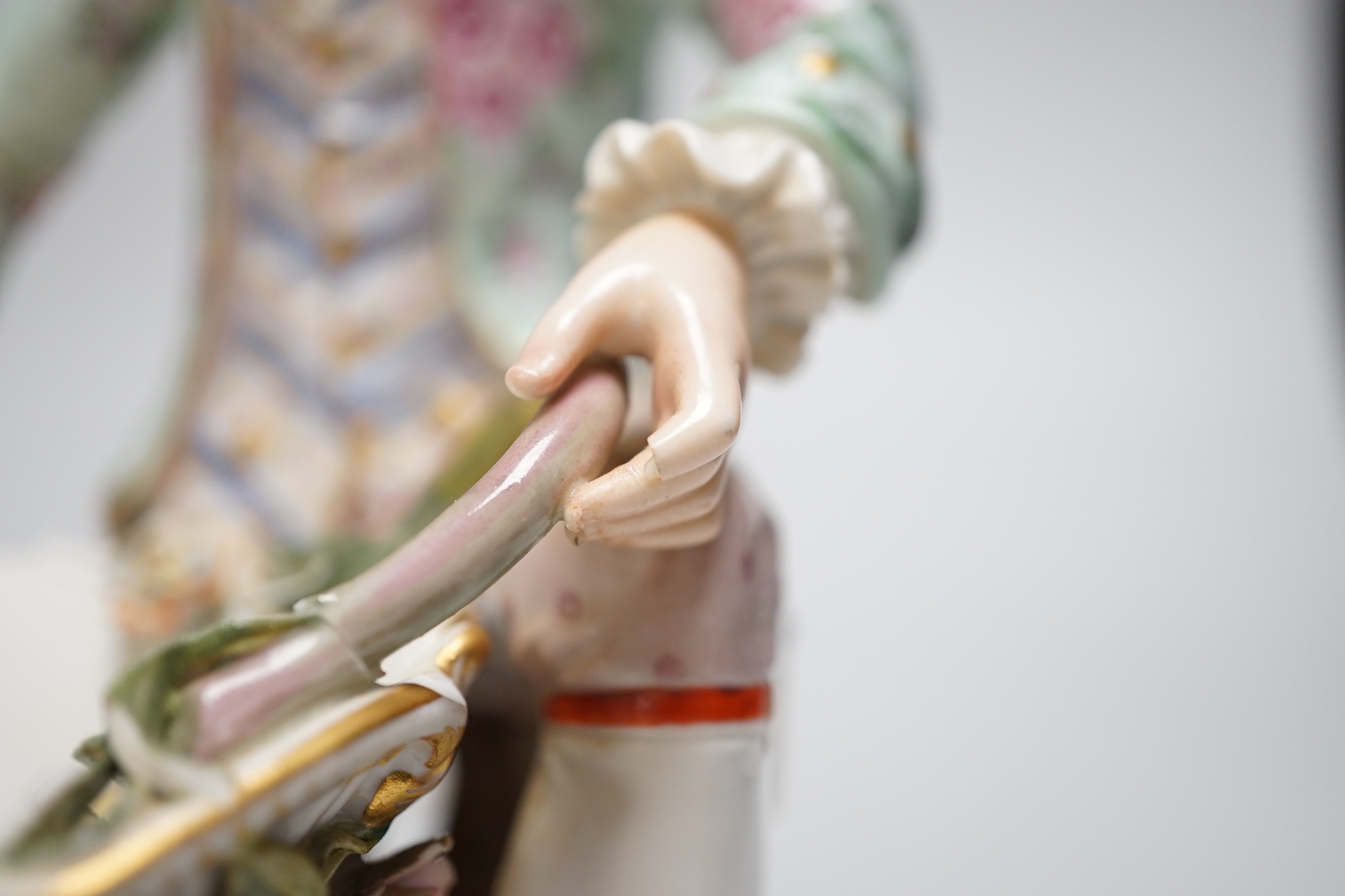 A large pair of Meissen salts in the form of a seated man and a woman in 18th century dress (a.f.), 21cm high